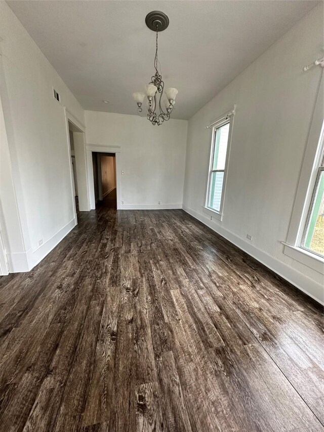 empty room with ceiling fan, a healthy amount of sunlight, and dark hardwood / wood-style floors