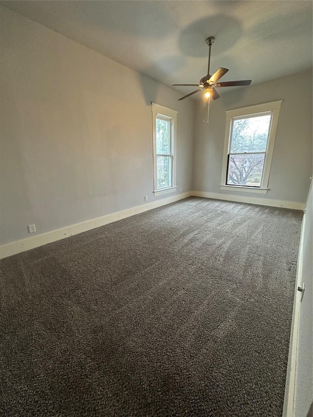 empty room featuring ceiling fan and carpet