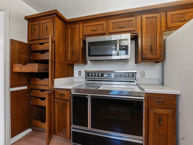 kitchen featuring white refrigerator, light hardwood / wood-style flooring, and range with electric stovetop