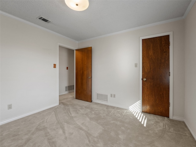 carpeted empty room featuring a textured ceiling and ornamental molding