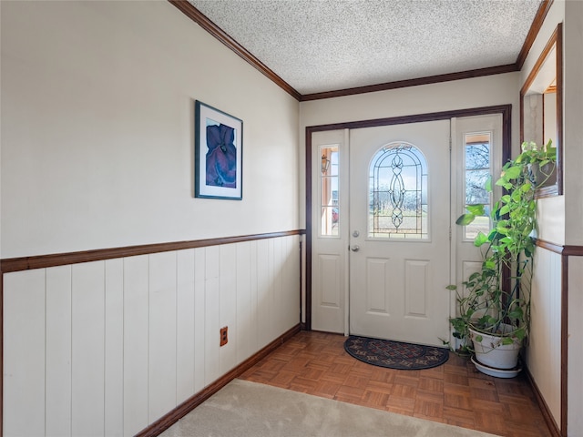 foyer with crown molding, a textured ceiling, and light parquet flooring