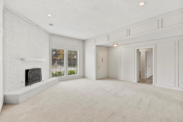 unfurnished living room featuring a fireplace, a textured ceiling, and light carpet