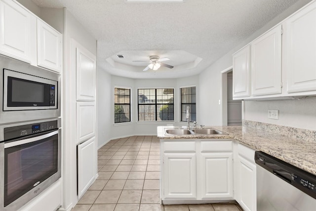 kitchen with sink, white cabinetry, a tray ceiling, and appliances with stainless steel finishes