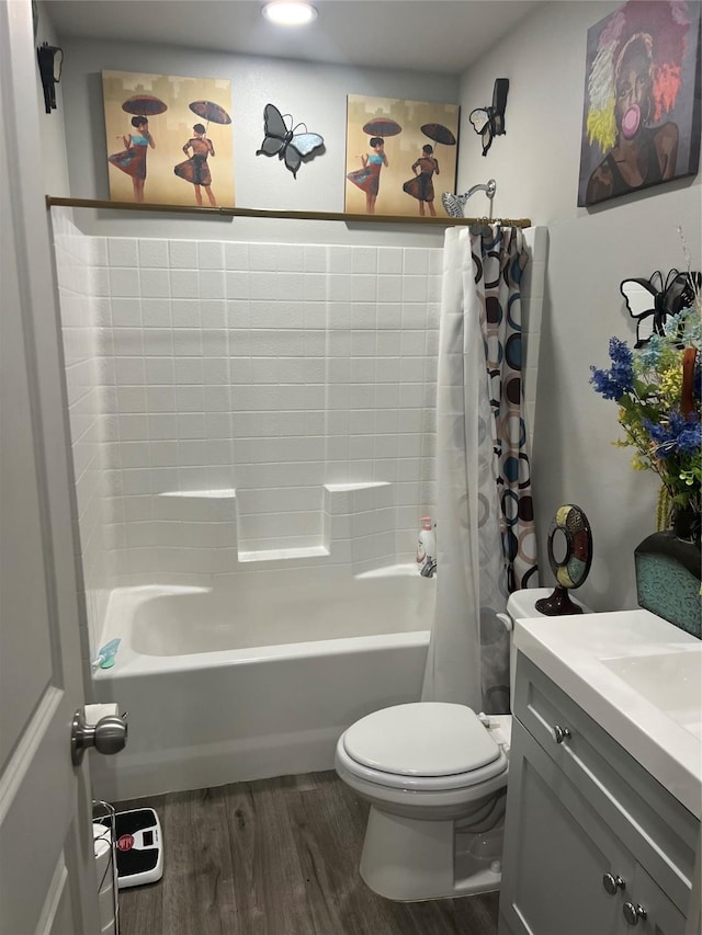 full bathroom featuring toilet, vanity, wood finished floors, and shower / tub combo with curtain