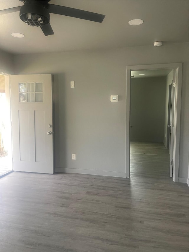 spare room with a ceiling fan, baseboards, and wood finished floors