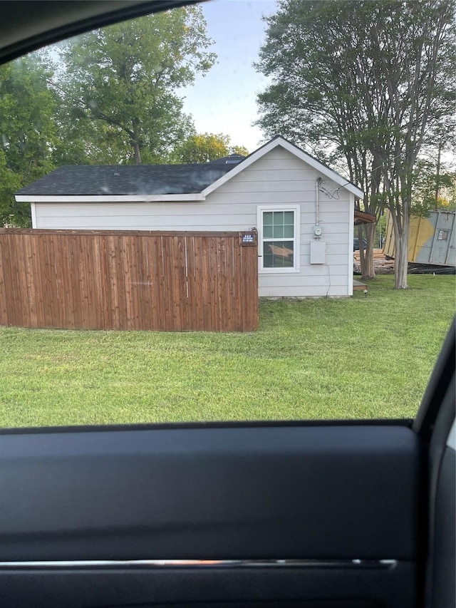 view of home's exterior with fence and a yard