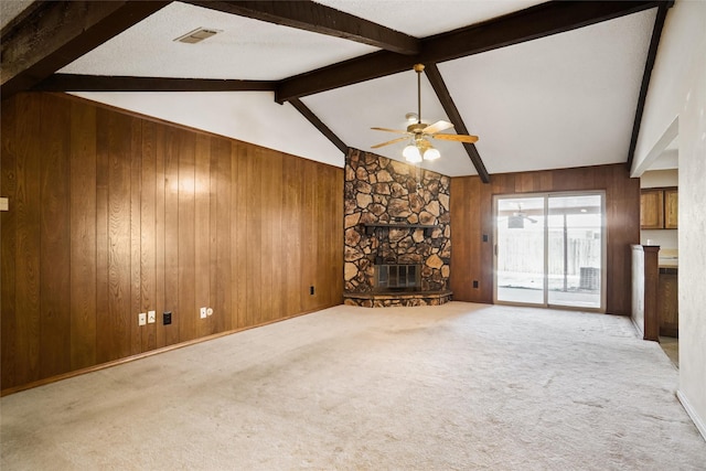 unfurnished living room featuring vaulted ceiling with beams, wood walls, and a fireplace