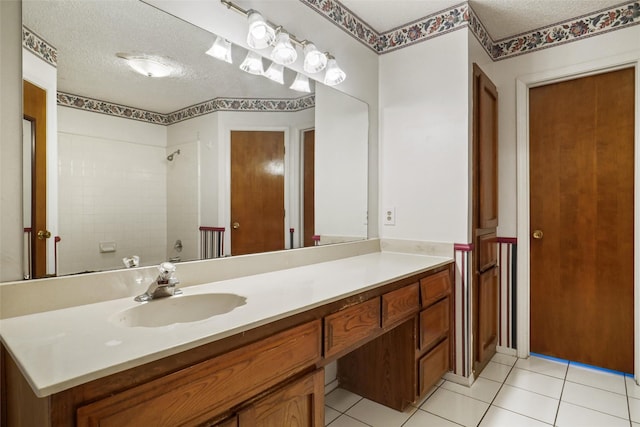 bathroom featuring vanity, a textured ceiling, tile patterned floors, and walk in shower