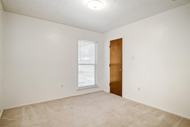 carpeted spare room featuring a textured ceiling