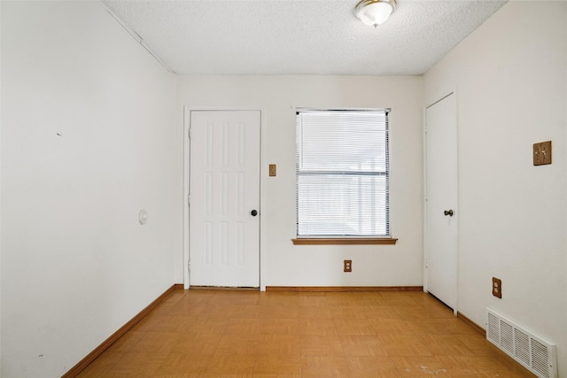 unfurnished room with a textured ceiling