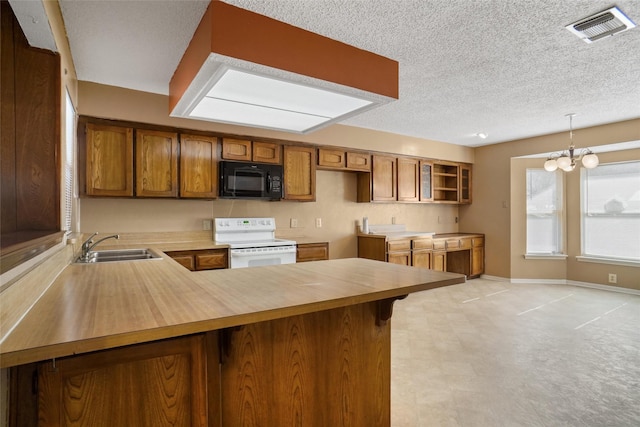 kitchen featuring sink, a notable chandelier, white range oven, kitchen peninsula, and decorative light fixtures