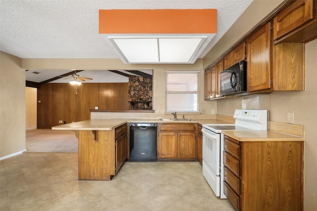 kitchen featuring kitchen peninsula, a kitchen breakfast bar, ceiling fan, sink, and black appliances