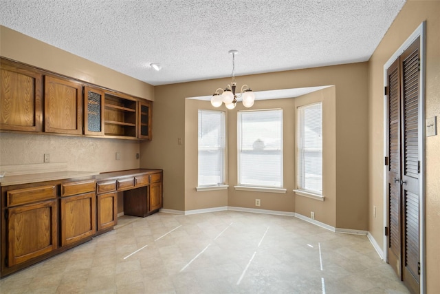 kitchen featuring a chandelier, pendant lighting, and a textured ceiling