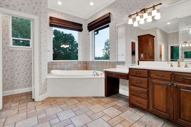 bathroom featuring vanity, ornamental molding, and a tub