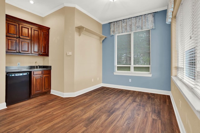 kitchen with sink, dark hardwood / wood-style flooring, crown molding, and black dishwasher