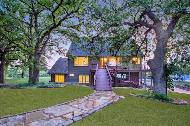 view of front of house with a wooden deck and a front lawn