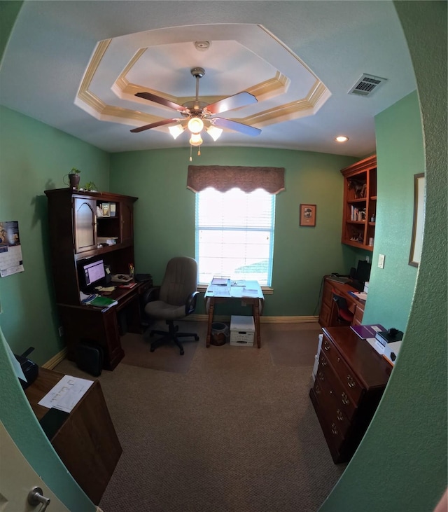 carpeted office featuring a raised ceiling and ceiling fan