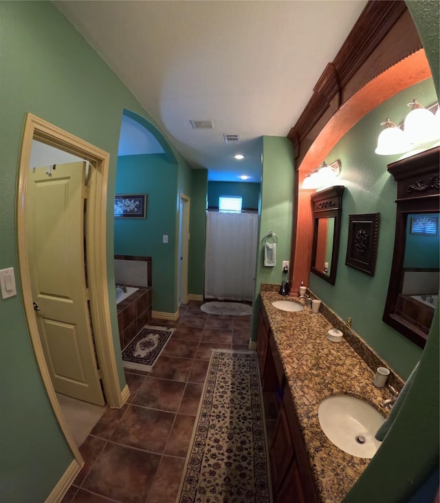 bathroom featuring tile patterned floors, vanity, and a bath