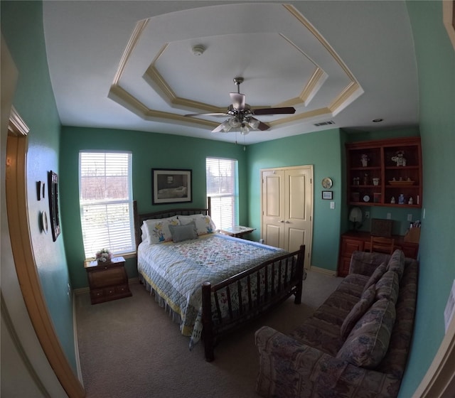 bedroom with ceiling fan, a raised ceiling, carpet floors, and a closet