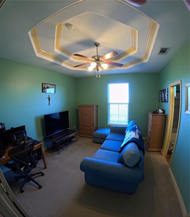 living room featuring a raised ceiling, ceiling fan, and carpet floors