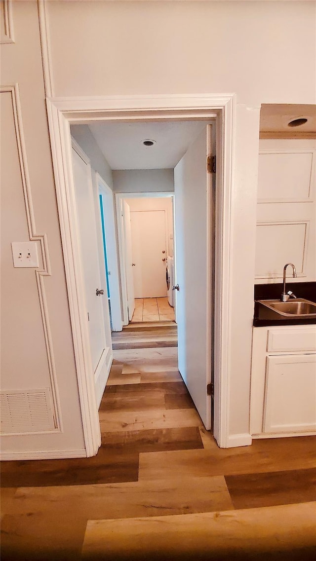 hallway featuring light hardwood / wood-style floors and sink