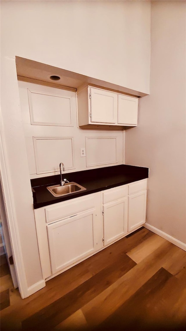 kitchen featuring sink, white cabinets, and dark wood-type flooring