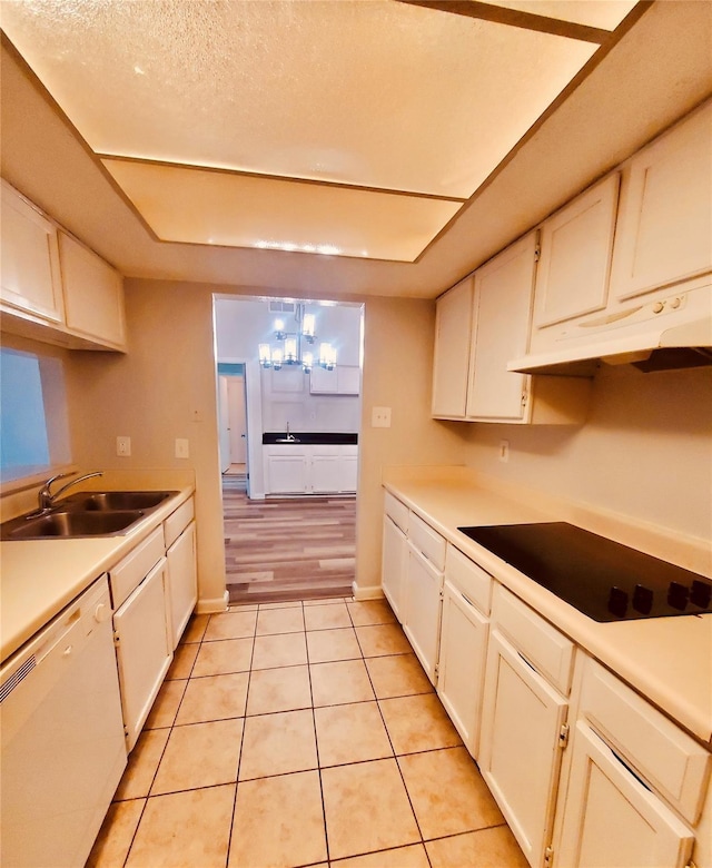 kitchen featuring black electric stovetop, white dishwasher, white cabinetry, and sink