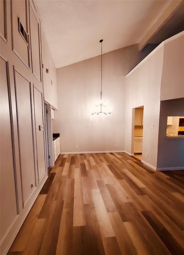 unfurnished dining area featuring dark hardwood / wood-style floors and high vaulted ceiling