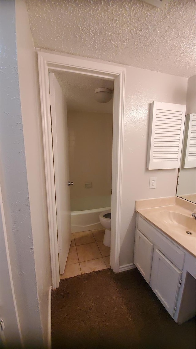 bathroom with vanity, a bathtub, tile patterned flooring, toilet, and a textured ceiling