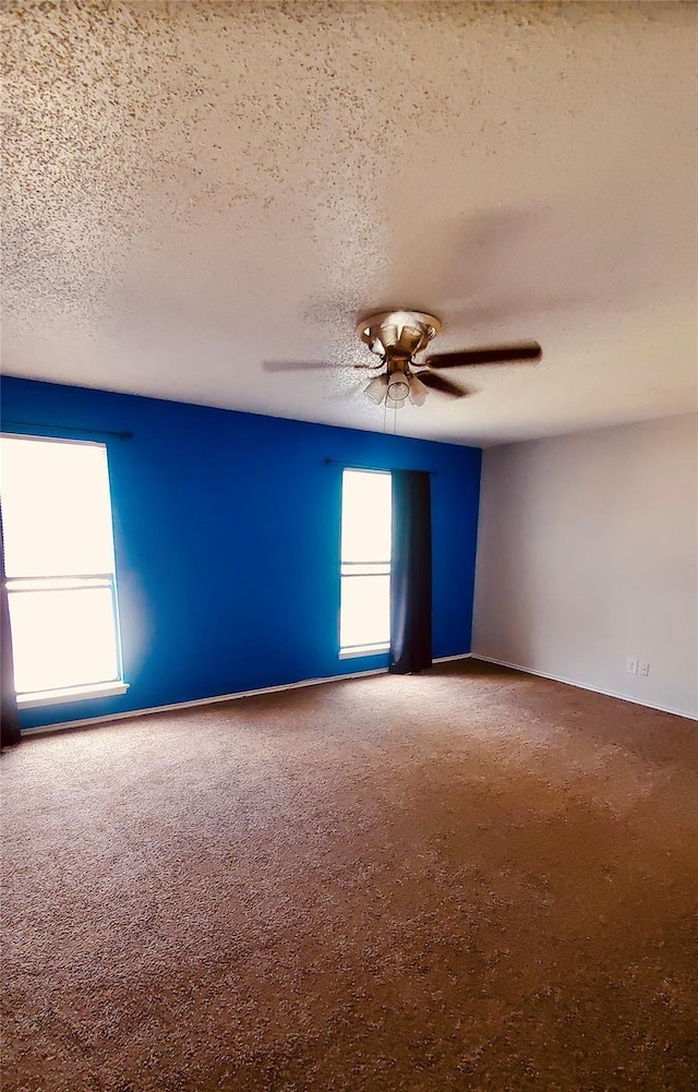 carpeted empty room with a textured ceiling and ceiling fan