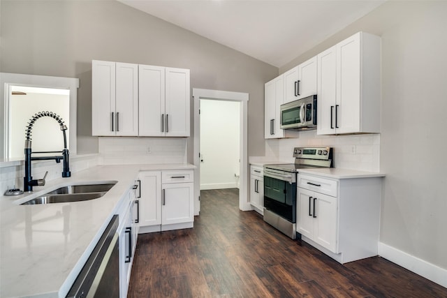 kitchen with backsplash, stainless steel appliances, sink, dark hardwood / wood-style floors, and white cabinetry