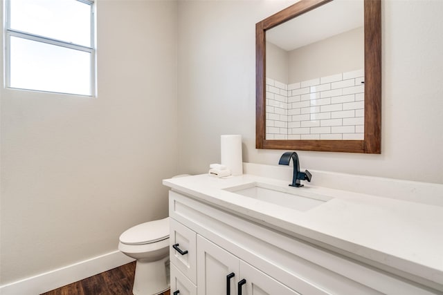 bathroom featuring vanity, wood-type flooring, and toilet