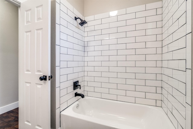 bathroom with hardwood / wood-style flooring and tiled shower / bath