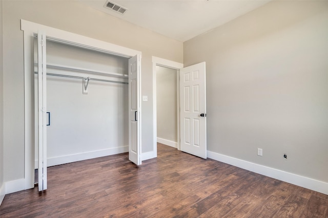 unfurnished bedroom featuring dark wood-type flooring and a closet