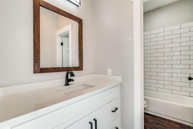 full bathroom featuring wood-type flooring, vanity, toilet, and tiled shower / bath