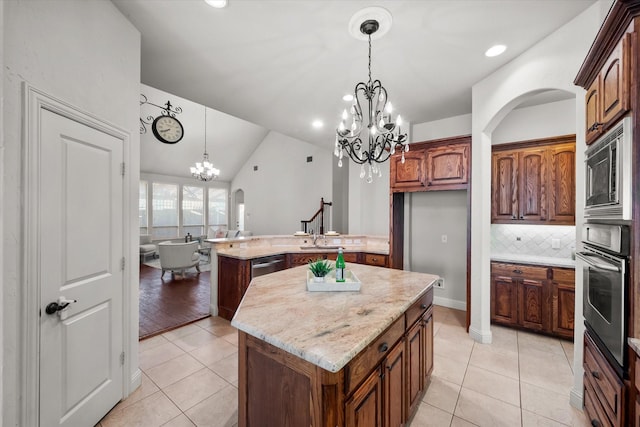 kitchen featuring a kitchen island, appliances with stainless steel finishes, lofted ceiling, and decorative backsplash