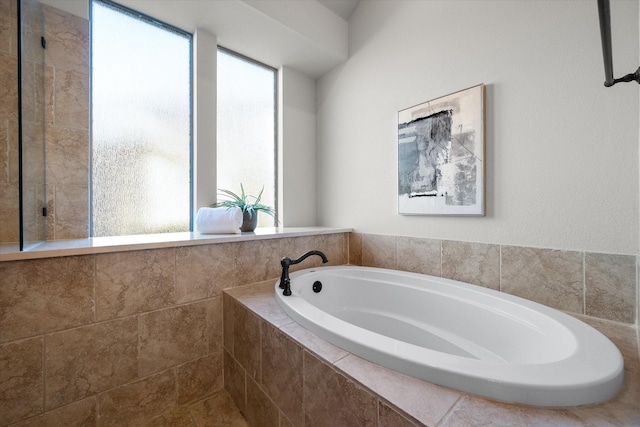 bathroom featuring a relaxing tiled tub