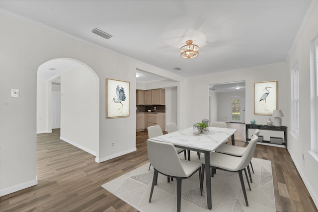 dining area with hardwood / wood-style floors and ornamental molding