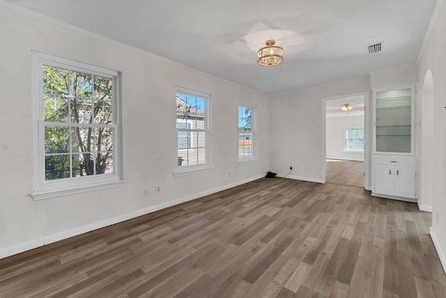 unfurnished room featuring ceiling fan, crown molding, and dark wood-type flooring