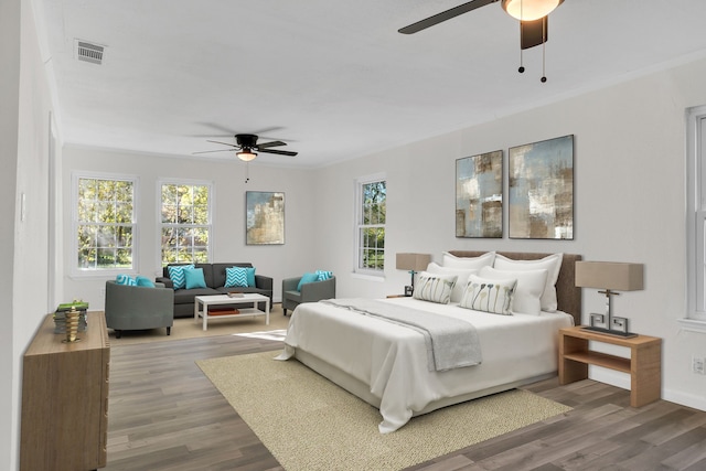 bedroom with ceiling fan, wood-type flooring, and ornamental molding