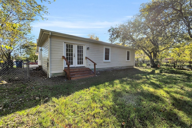 back of house featuring a yard and french doors