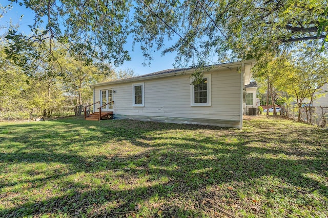 back of house featuring a yard and central AC unit