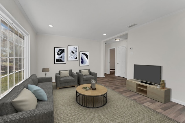 living room with a wealth of natural light, dark hardwood / wood-style flooring, and crown molding