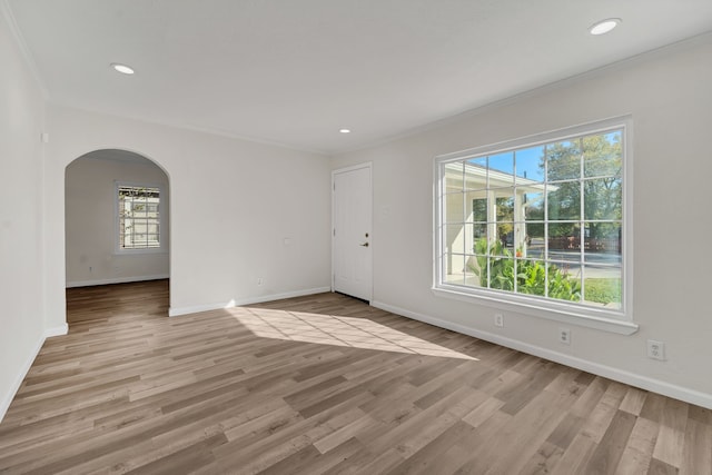 spare room featuring light hardwood / wood-style flooring and ornamental molding