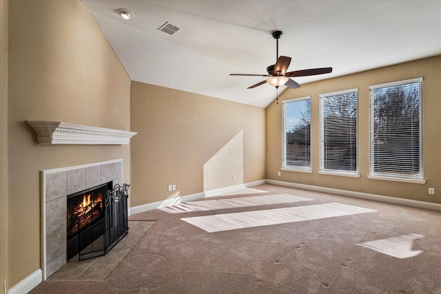 unfurnished living room featuring baseboards, visible vents, vaulted ceiling, carpet flooring, and a fireplace