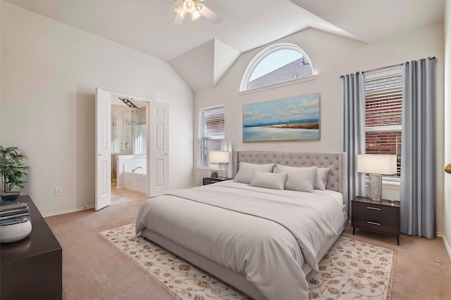 bedroom featuring light colored carpet, vaulted ceiling, ceiling fan, ensuite bath, and baseboards