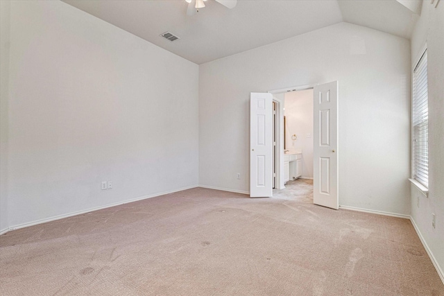 empty room with ceiling fan, light carpet, visible vents, baseboards, and vaulted ceiling