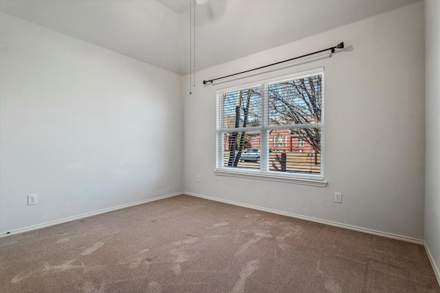 carpeted empty room featuring baseboards