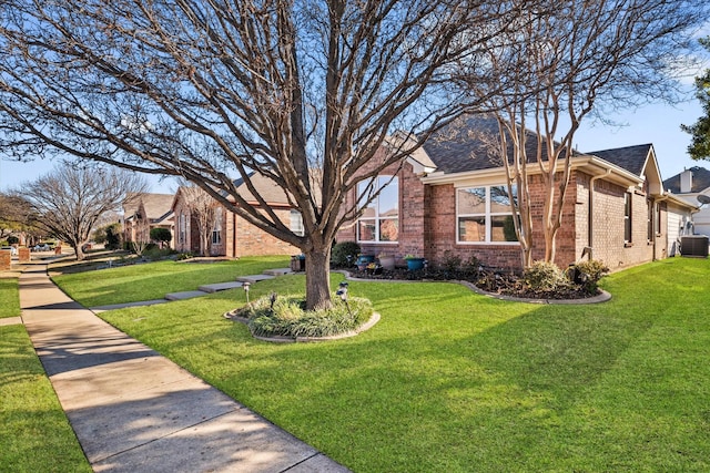 exterior space with central air condition unit, roof with shingles, a front lawn, and brick siding