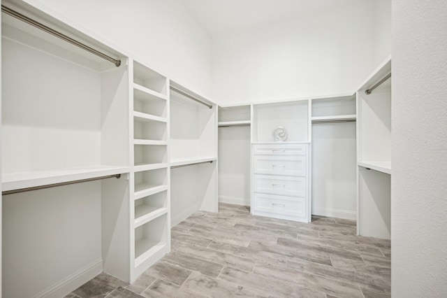 walk in closet with light hardwood / wood-style floors